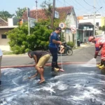 Sejumlah Pemotor Terjatuh, Petugas Damkar Kota Madiun Bersihkan Oli Bocor Dari Truk